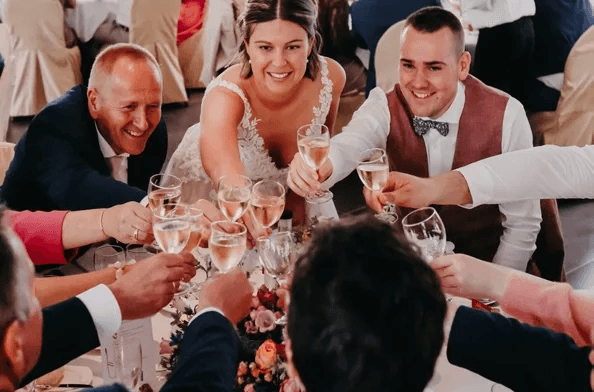 trouwkoppel dat met gasten klinkt met glazen champagne